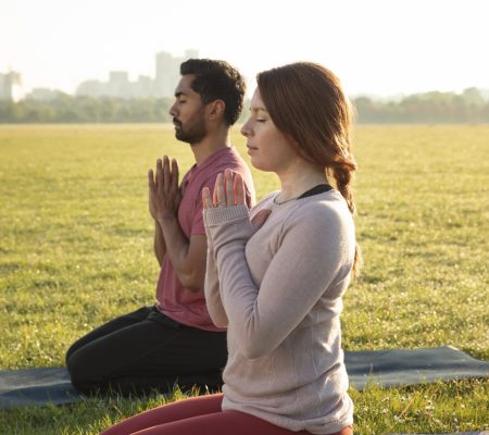 side-view-man-woman-meditating-outdoors-yoga-mats-min